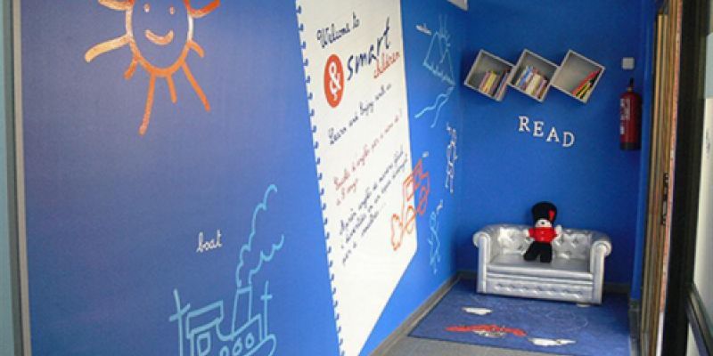 Imatge d´interior d´acadèmia de Smart children amb parets de color blau, dibuixos infantils i ninot de guàrdia anglès