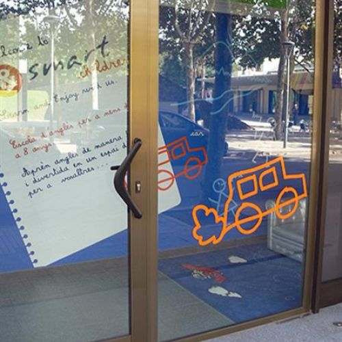 Foto de puerta con vinilos de dibujos infantiles de coches y pared con dibujo de hoja de cuaderno