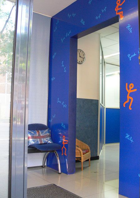 Entrada a aula amb parets en colors blau elèctric i taronja