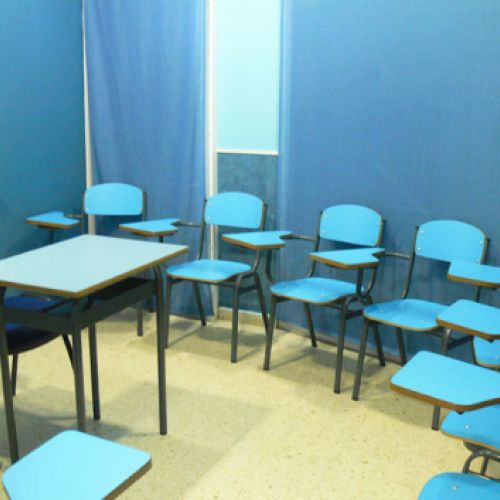 Interior de aula con paredes y pupitres de color azul