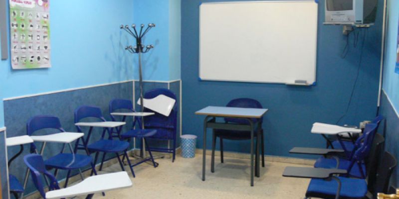 Interior d´aula amb parets i taules de color blau