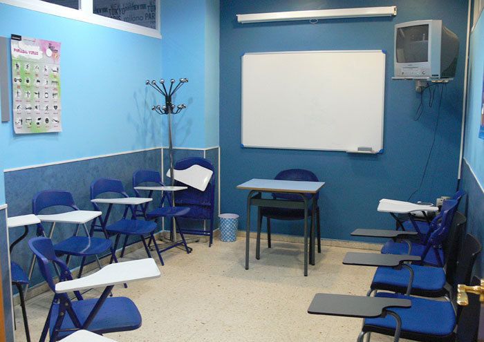 Interior d´aula amb parets i taules de color blau