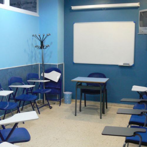 Interior de aula con paredes y mesas de color azul