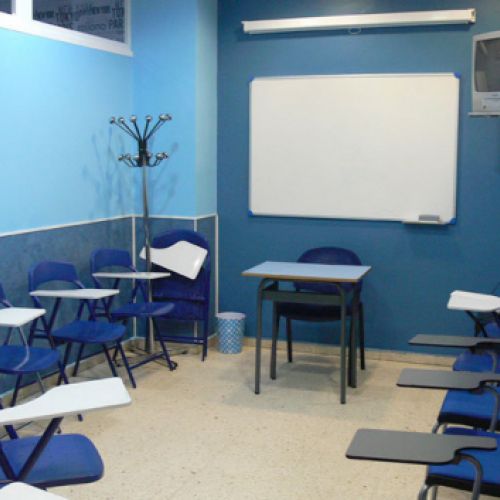 Interior d´aula amb parets i taules de color blau
