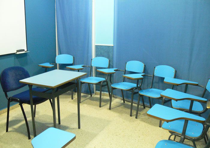 Interior de aula con paredes y pupitres de color azul